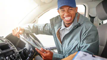 Smiling truck driver looks out the cabin window